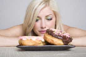 woman eating donuts, which might cause colon cancer
