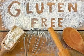 gluten free written in cooking flour on wood along with cooking utensils
