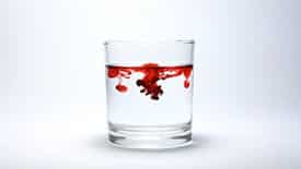 blood dispersing in glass of water, which represents blood in toilet